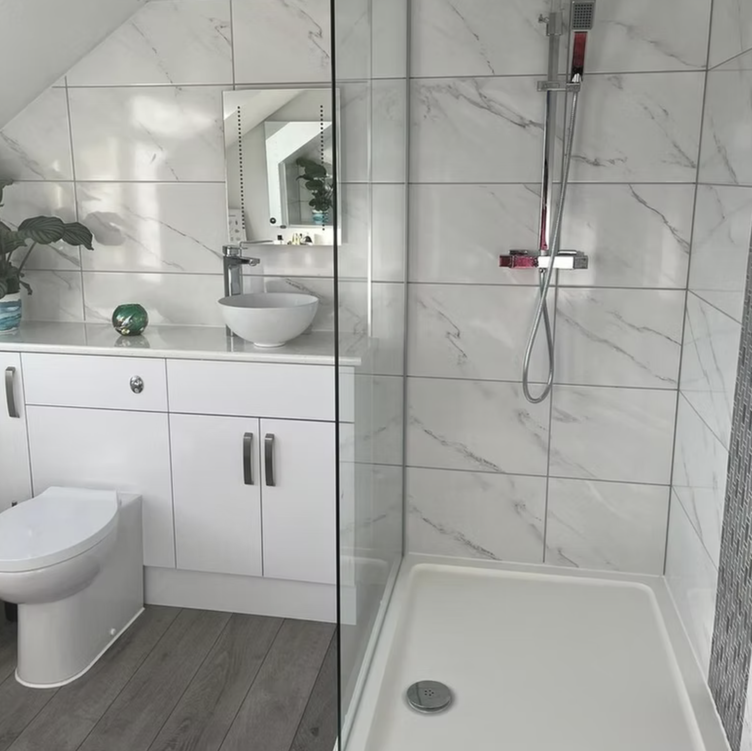 A walk-in shower and floating vanity in a marble-effect loft bathroom.
